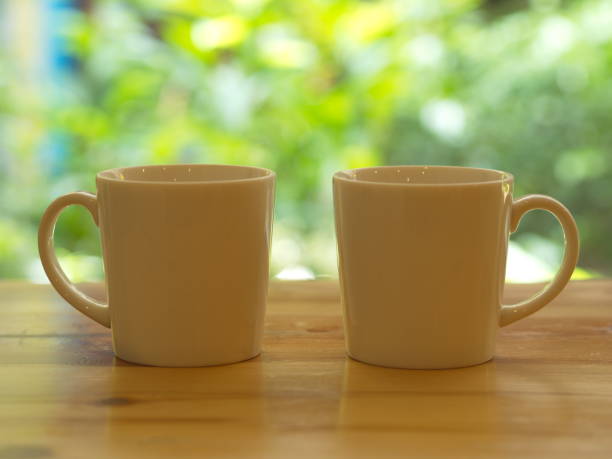 istock Closeup White Cofee Cup  with Green leaf bokeh. 1002612050
