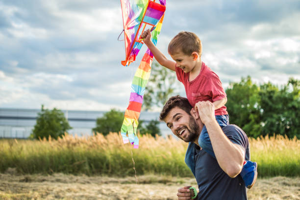 istock Little boy flying a kite with his father 1002612262
