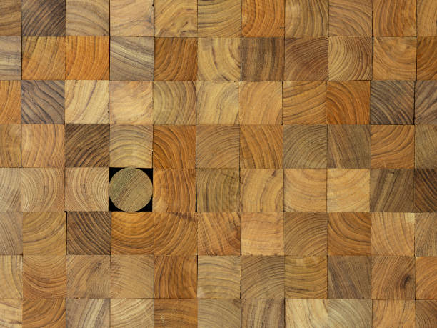 istock Many wood square profiles stacked up at the same length with one round profile length within the background standing out from the crowd. 1002612280