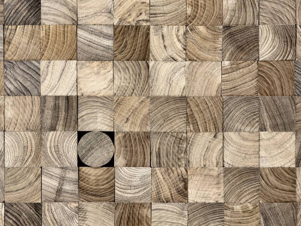 istock Many wood square profiles stacked up at the same length with one round profile length within the background standing out from the crowd. 1002612298