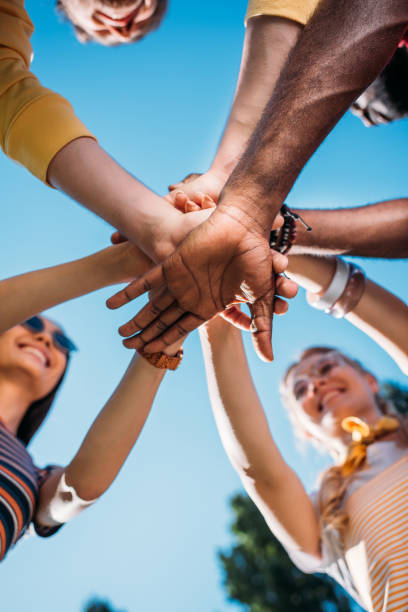 Low angle shot of an unrecognisable group of friends standing and stacking their hands together