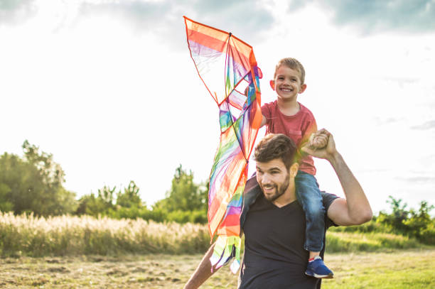 istock Little boy flying a kite with his father 1002625000