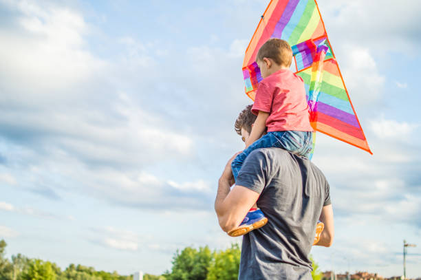 istock Little boy flying a kite with his father 1002625410