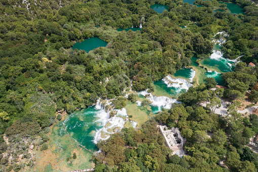 Aerial of the famous staircase waterfalls at the beautiful Krka National Park, Croatia. You can see thousands of tourists bathing by the bridge and the lower bay. Converted from RAW.