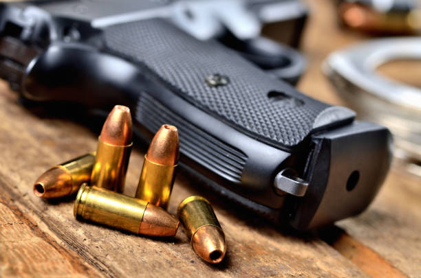 istock Close-up of 9mm pistol, bullets and handcuffs 1002628242