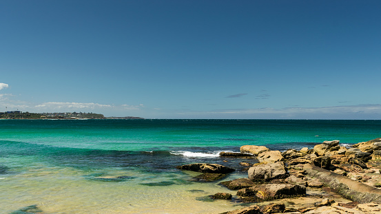 Landscape of rocks on the beach with horizon in the background - Manly Beach, Sydney, Australia