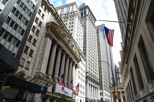 New York City, USA - June 20, 2018: Low angle view of  New Stock Stock Exchange building and American flag from Broad Street