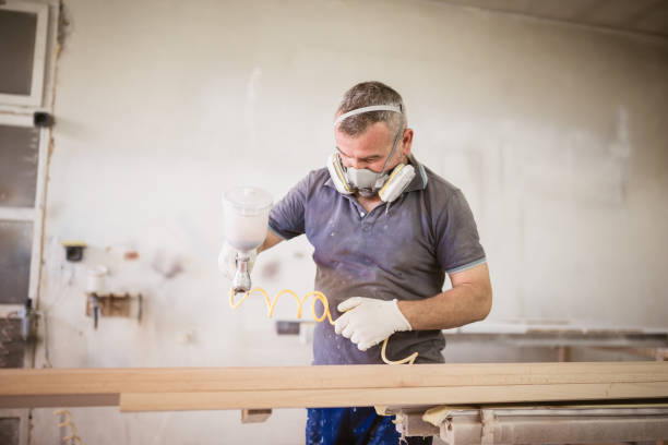 istock Carpenters painting wood in workshop 1002660318