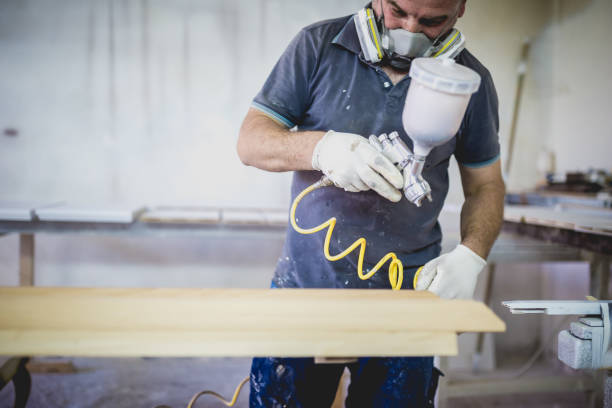 istock Carpenters painting wood in workshop 1002660322