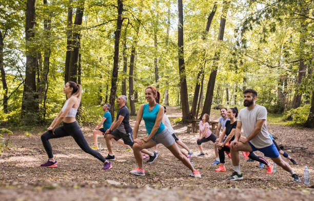 istock Group of athletes stretching their legs in the forest. 1002660330