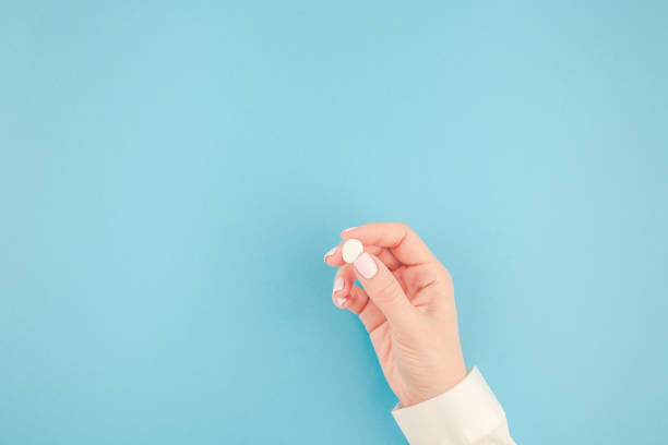 istock Female hand holding a white pill 1002662868