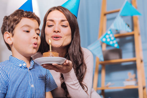 istock Cheerful brunette blowing out candle 1002663564