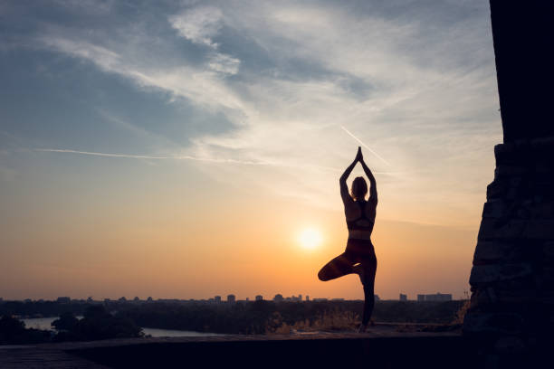 istock Woman practicing yoga outdoors. Summer sunset 1002663656