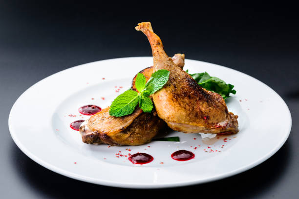 istock Juicy delicious cooked duck legs served with herbs and sauce in 1002666690