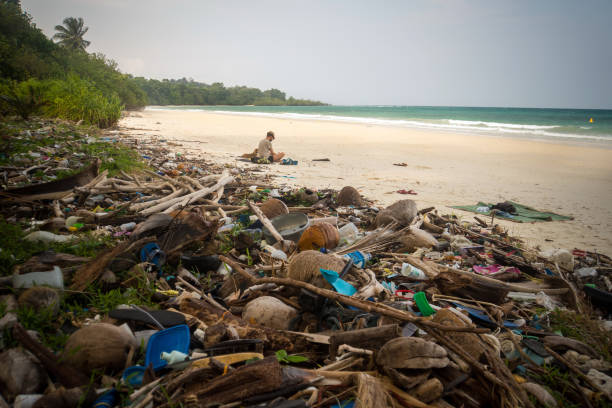 ретро фильтрованный мусор на пляже, оставленный туристом, - cigarette wrapping стоковые фото и изображения