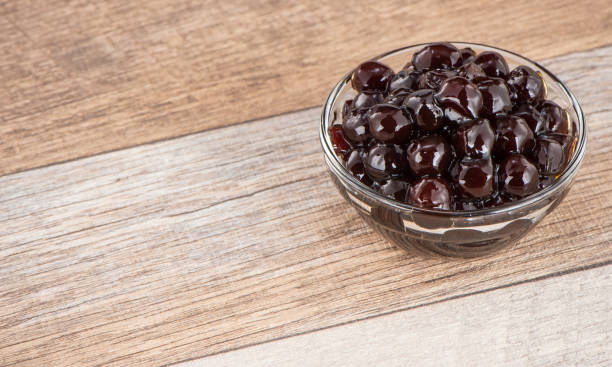istock Tapioca Pearl , Bubble topping for tea or other beverage, in a cup, place on wooden table. Copy space 1002671036
