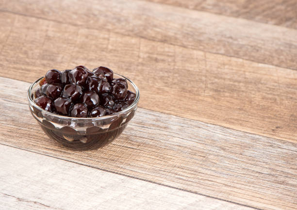 istock Tapioca Pearl , Bubble topping for tea or other beverage, in a cup, place on wooden table. Copy space 1002671038