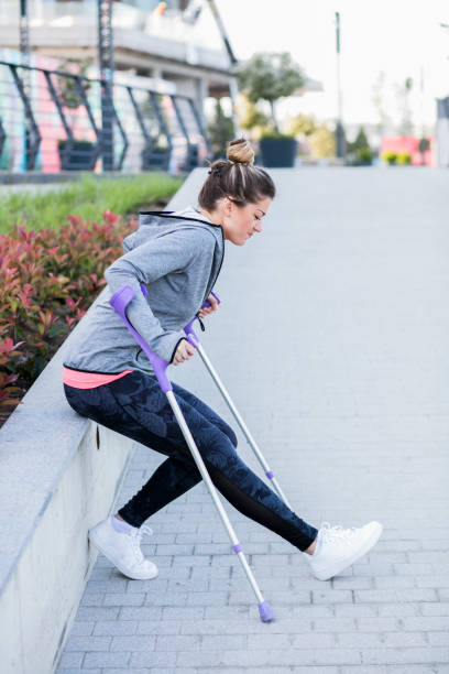 istock Young beautiful woman with crutches 1002671410