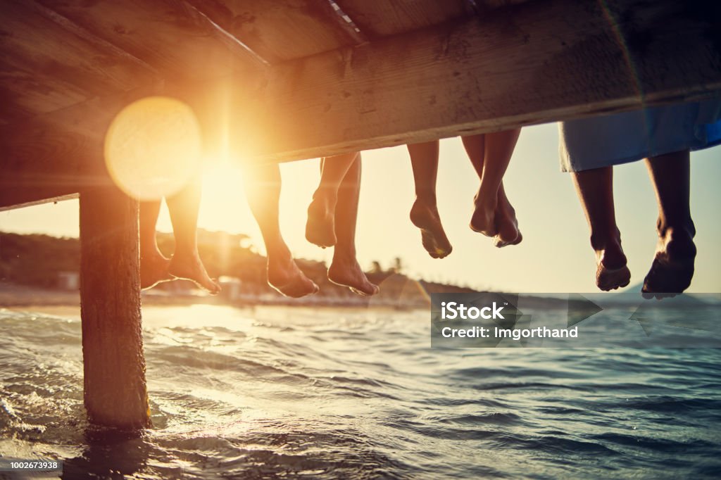 Famille assis sur la jetée à la mer - Photo de Famille libre de droits