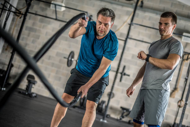 homme d’âge mûr exercer dans la salle de gym - différence dâge photos et images de collection