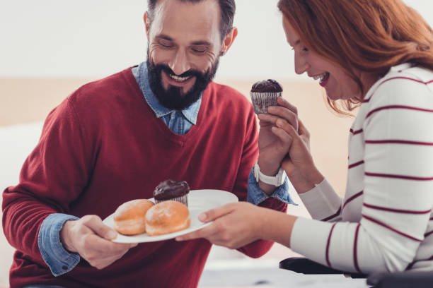 istock Happy couple laughing while looking at the cakes on the plate 1002675062