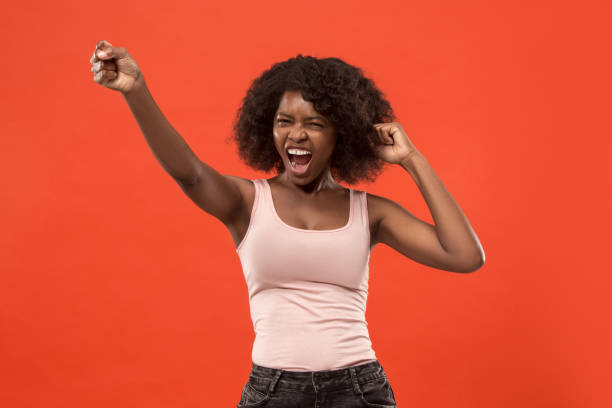 istock Winning success woman happy ecstatic celebrating being a winner. Dynamic energetic image of female afro model 1002677716