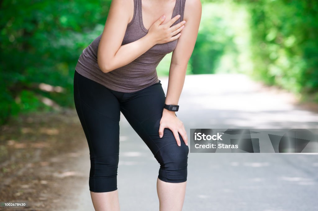 Woman with heart attack, injury while running, trauma during workout Woman with heart attack, injury while running, trauma during workout, outdoors concept Chest Pain Stock Photo