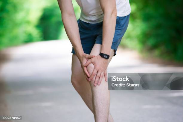 Pain In Knee Joint Inflammation Massage Of Male Leg Injury While Running Trauma During Workout Stock Photo - Download Image Now