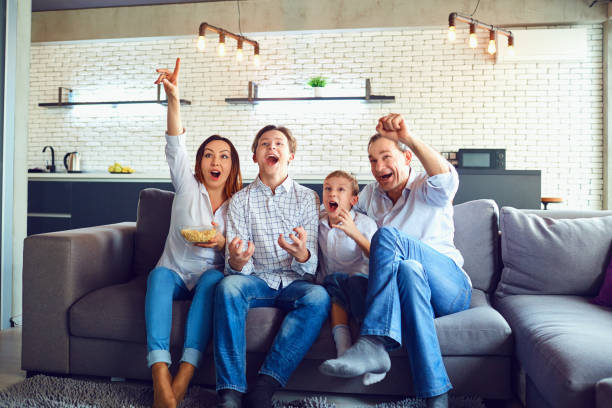 istock A cheerful family is playing video games while sitting on a sofa 1002683792