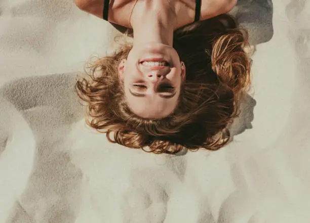 Photo of Close up of woman relaxing on beach sand