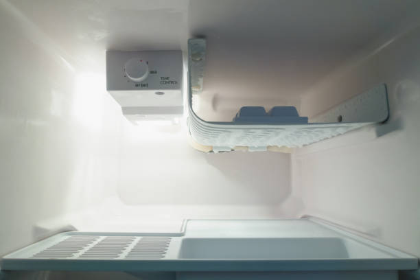 istock Empty open of small refrigerator with ice buildup on the freezer. 1002685592