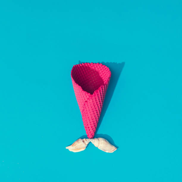 istock Creative summer layout with sea shells and icecream cone on bright blue background. Minimal mermaid concept. Flat lay. 1002696116