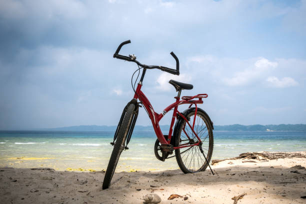 istock bicycle at the beach on blue sky 1002702416