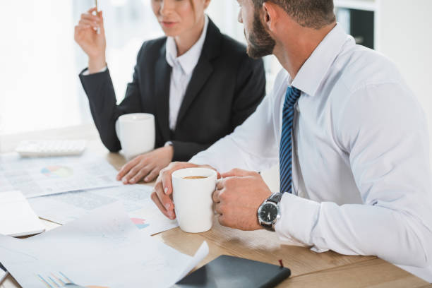 istock cropped image of financiers working with documents during coffee break in office 1002705328