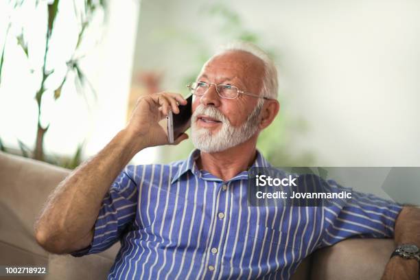 Senior Man Chatting On A Mobile Phone At Home Stock Photo - Download Image Now - Using Phone, Mature Men, Senior Adult