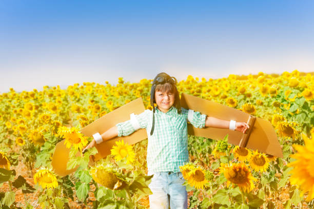 istock Happy little boy playing pilot in sunflower field 1002719660
