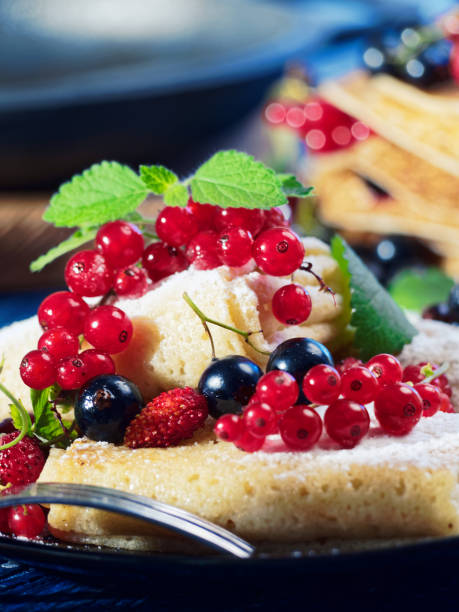 Making and serving stuffed crepes with various fresh berries