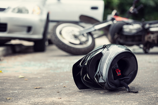 Primer plano de un casco de un conductor con una borrosa moto y coche en el fondo photo