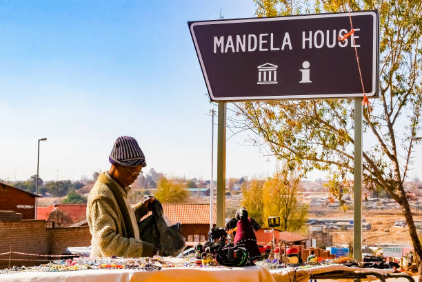 Old Lady selling African Curios on sale Outside Nelson Mandela's house in Vilakazi Street Soweto Johannesburg, South Africa, July 12, 2009, Old Lady selling African Curios on sale Outside Nelson Mandela's house in Vilakazi Street Soweto soweto stock pictures, royalty-free photos & images