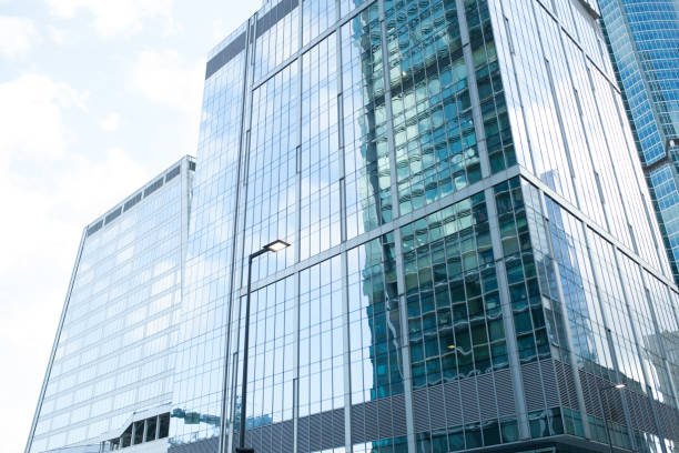 istock Detail blue glass building background with cloud sky 1002729240