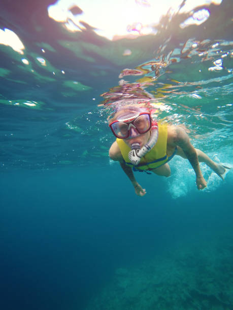 istock Woman snorkeling under the sea 1002732242