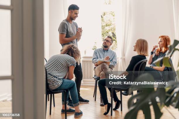 Happy Hispanic Man Talking To His Support Group About His Successful Fight With Drug Addiction Stock Photo - Download Image Now