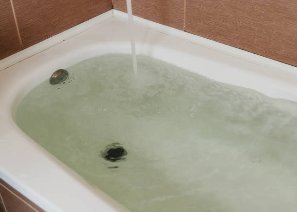 istock Water poured into the tub. Full bath. Close up. 1002737580