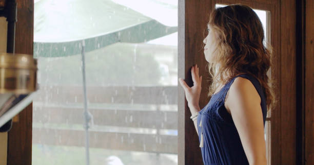 istock woman watching rain at cafe. 1002737620