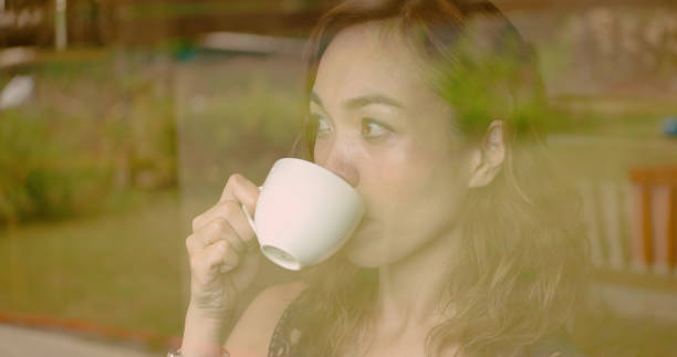 istock woman watching rain at cafe. 1002737718
