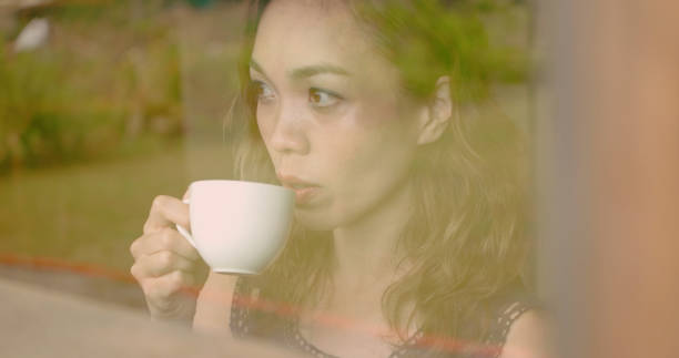 istock woman watching rain at cafe. 1002737750