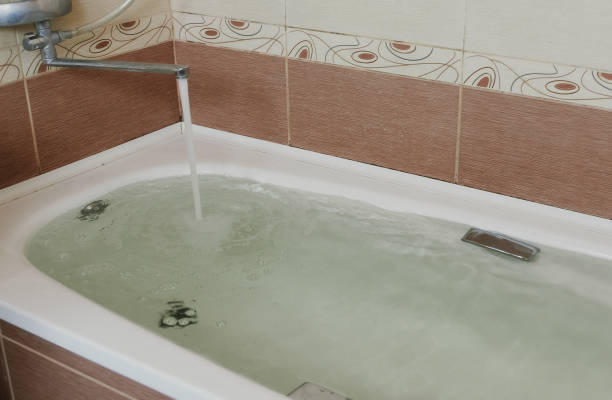 istock Water poured into the tub. Full bath. Close up. 1002737952