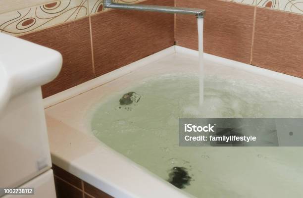 Strong Stream Of Water Pours Into The Tub Water Pours Out Tub Overflows Close Up Stock Photo - Download Image Now