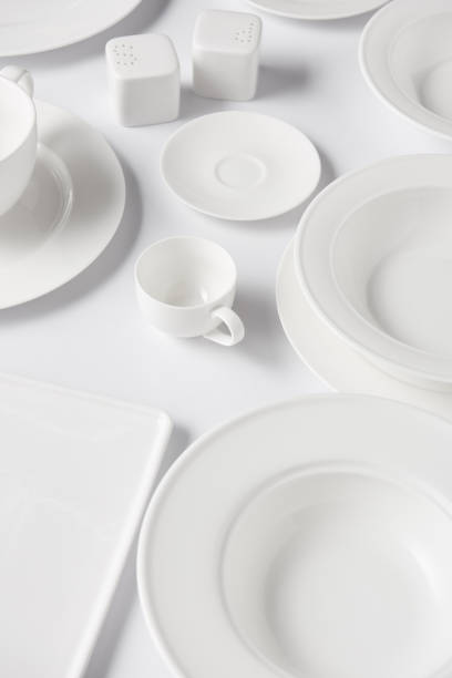 istock high angle view of different plates, cups, saltcellar and pepper caster on white table 1002740660