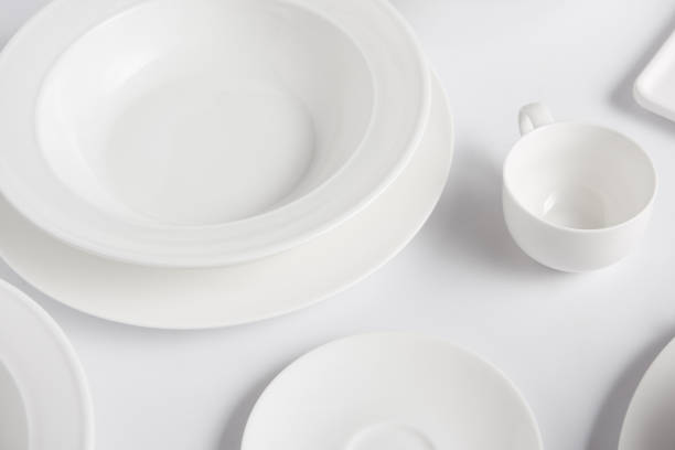istock selective focus of different plates and cup on white table 1002740692